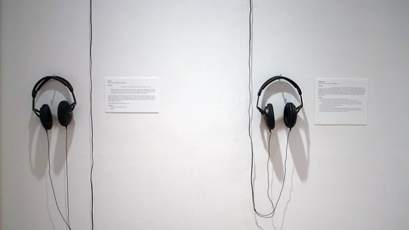 Headphones haning on a wall in the installation.