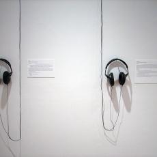 Headphones haning on a wall in the installation.